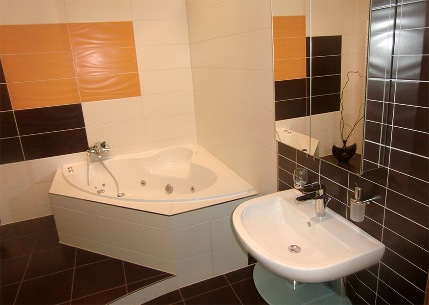 Modernes Badezimmer weiß gefliest, aufgelockert mit farbigen, orangen